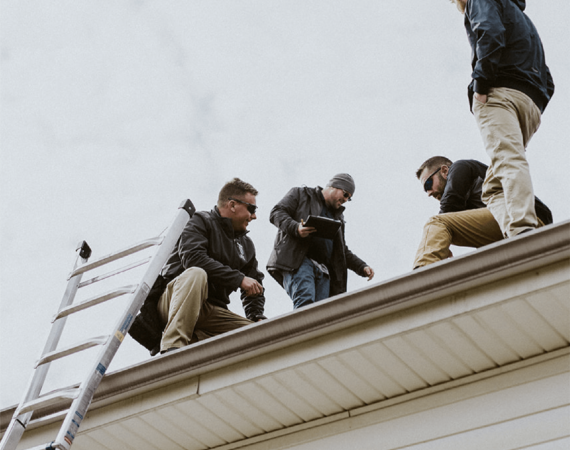 men working on a roof with a ladder