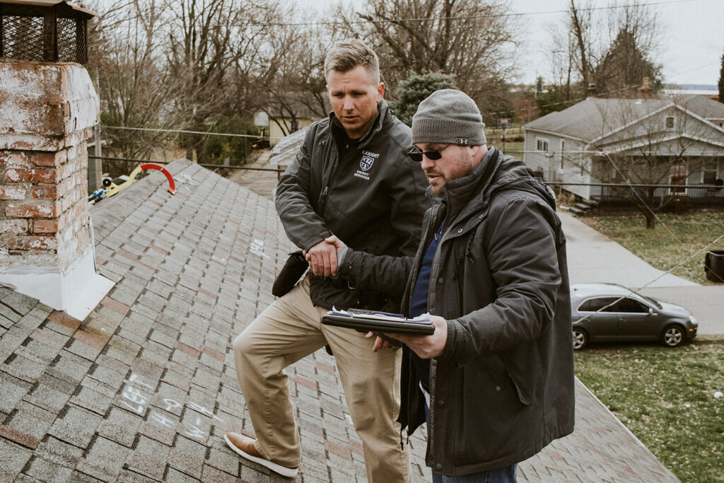 Two Knight's Solutions Technicians shaking hands on a roof-top inspection.